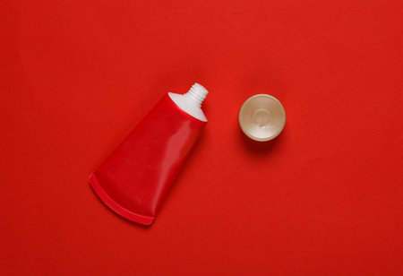 Open Red tube of cream on a red background. top viewの写真素材