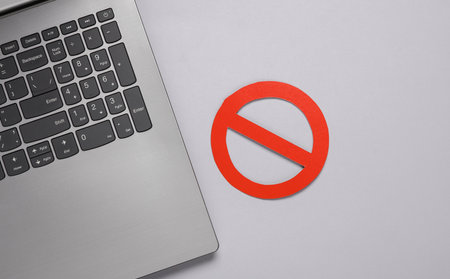 Laptop with prohibition sign on gray backgroundの写真素材