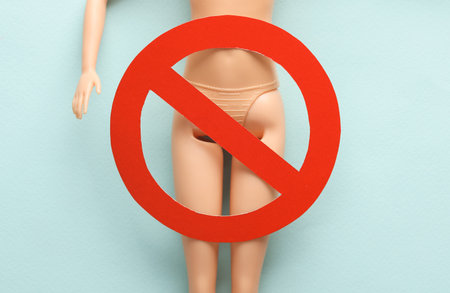 The naked body of a doll with a prohibition sign on a blue background. Gynecological problems