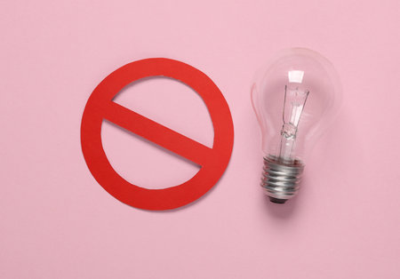 Incandescent light bulb with a prohibition sign on a pink background. Eco conceptの写真素材