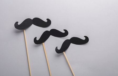 Paper mustache on a stick on a gray background. Party, photo booth, father's day. flat layの写真素材