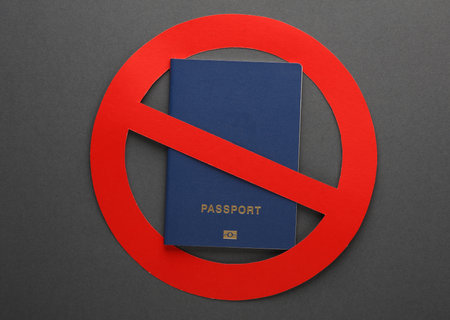 Entry ban, sanctions, deprivation of citizenship. Passport with prohibition sign on dark backgroundの写真素材