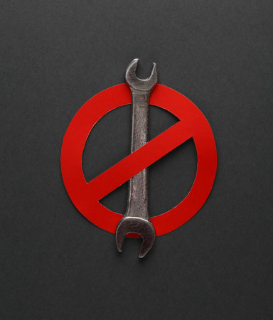Wrench with a prohibition sign on a dark gray backgroundの写真素材