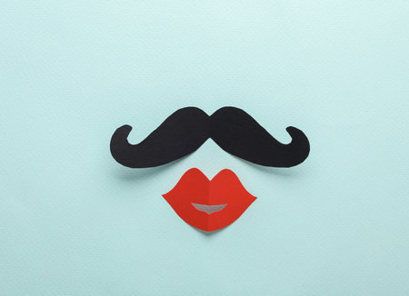 Creative layout of a male mustache with female lips on a blue backgroundの写真素材