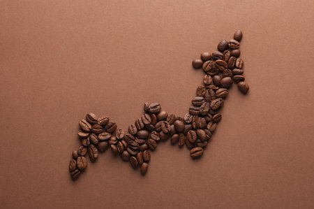 Coffee beans in the shape of a growth arrow curve on a brown backgroundの写真素材