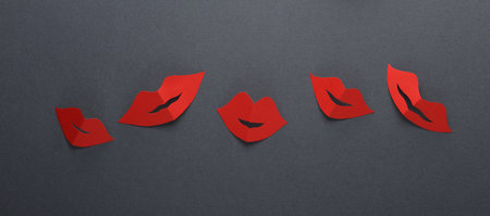 Red paper female lips on dark background. World Women's Day. March 8, feminism.の写真素材