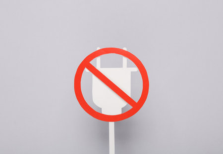 Paper electric plug with a prohibition sign on a gray backgroundの写真素材