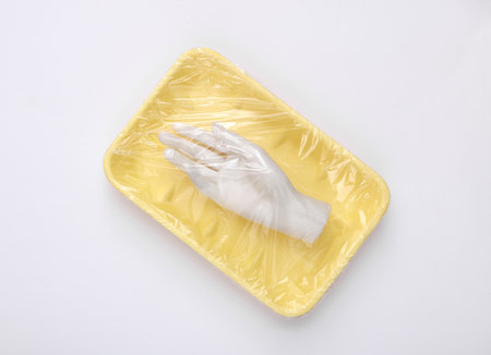 Mannequin hand in package wrapped with cellophane film on white background. creative ideas. minimal...