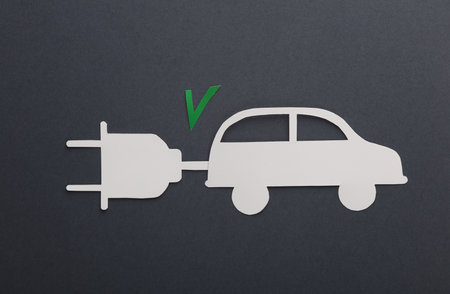 electric car. Paper cut car with electric plug and acceptance checkmark on dark background