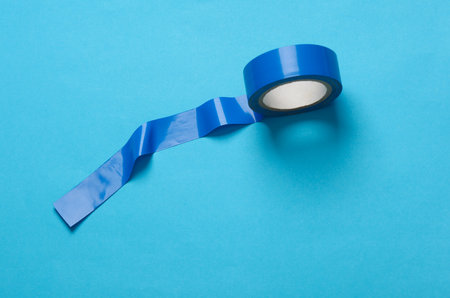 Roll of blue electrical tape on blue backgroundの写真素材