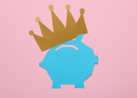 Paper-cut piggy bank with crown on pink backgroundの写真素材
