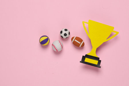 Paper-cut golden winner trophy cup with balls on pink background. Competition, sport, prize, award winners. top viewの写真素材