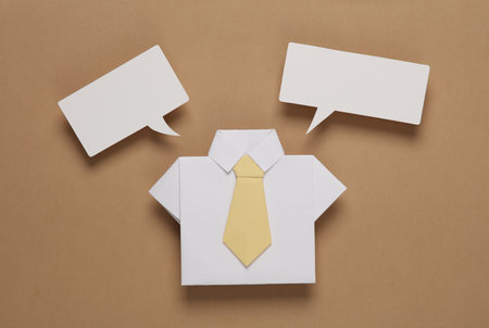 Origami shirt with a tie and a speech bubble on a brown background. business conceptの写真素材