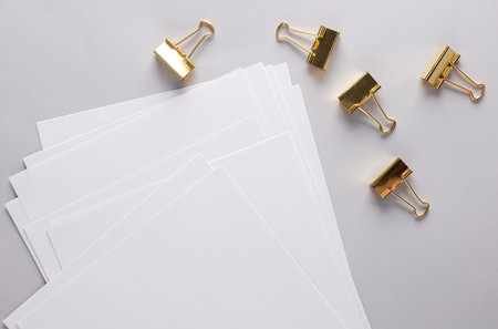 White blank sheets of a4 paper size or documents mockup and paper binder clips on gray background. Template for designの写真素材