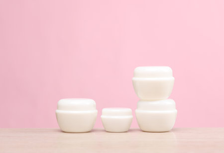 White cream jars on the table, pink background. creative layout. template for design. beauty mockupの写真素材