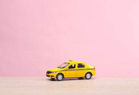 Miniature taxi car on a pink backgroundの写真素材