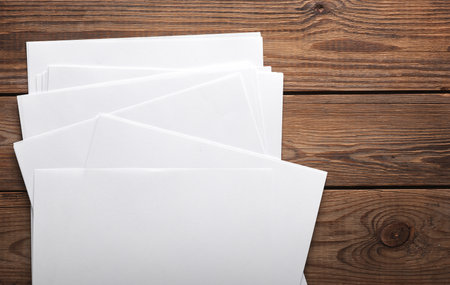 White blank sheets of a4 paper size or documents mockup on wooden table. Template for design