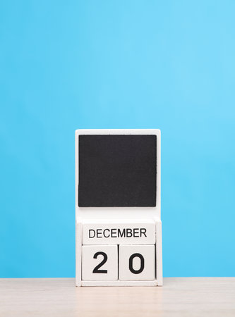 White wooden block monthly calendar with the date december 20 on the table, blue background. Planning, deadlineの写真素材