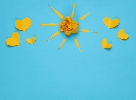 Paper sun with rays and hearts on a blue background. love concept. creative layoutの写真素材
