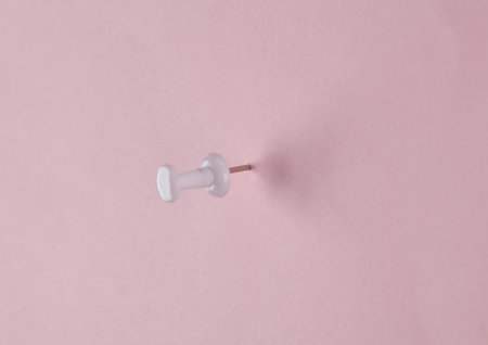 White push pinned on pink backgroundの写真素材