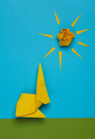 Scene made of paper Origami rabbit on the lawn with grass, sky and sunの写真素材