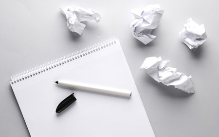 Lack of ideas. Sketchbook with crumpled paper and pen on gray background. top viewの写真素材