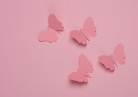 Butterflies cut out of paper on a pink background. spring backgroundの写真素材