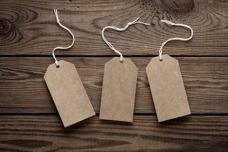 Empty craft price tags with string on wooden table. Template for designの写真素材