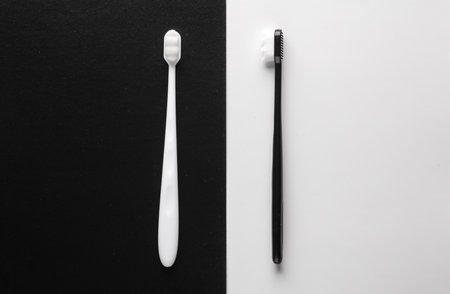 White and black toothbrushes on a white black background. top view.の写真素材