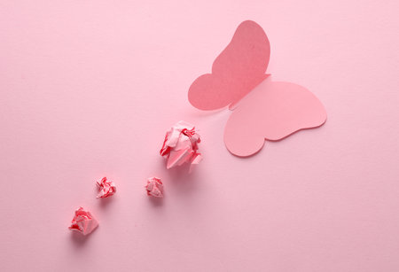 Butterfly cut out of paper on a pink backgroundの写真素材