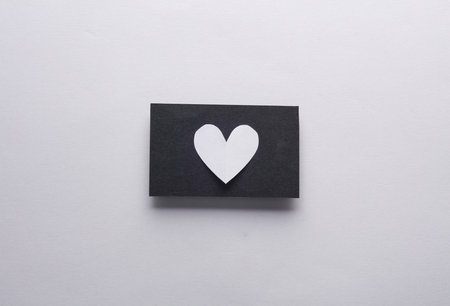Black business card with a heart on a gray backgroundの写真素材