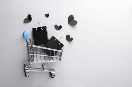 Sale, creative layout. Supermarket trolley with Black shopping bags and hearts. Black Friday. top viewの写真素材