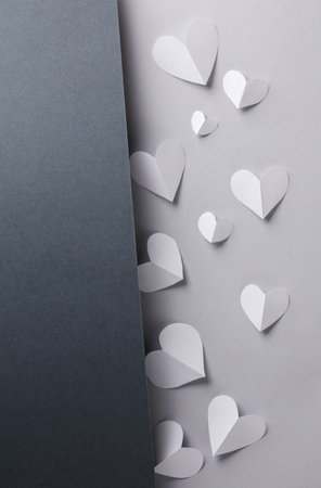 Paper cut white hearts on black and gray background. love concept. creative layout. minimalist compositionの写真素材