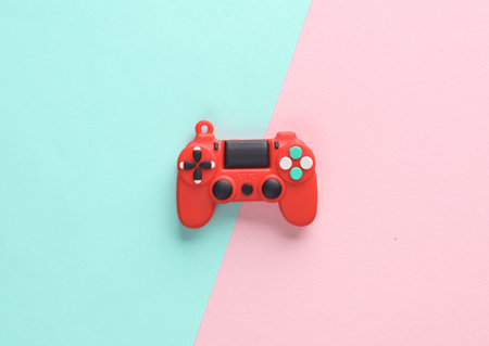 Red toy miniature gamepad on a pink blue background. top viewの写真素材