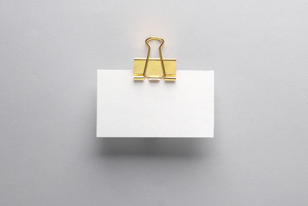 White business card mockup with golden binder on gray background. Template for designの写真素材