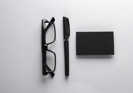creative business layout. Eyeglasses with a pen and black business card on a gray backgroundの写真素材