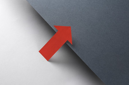 Red pointing arrow on black and gray background. creative layout. minimalist composition.の写真素材