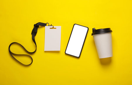 Coffee cup, smartphone and Empty white ID card badge mockup on yellow background. Staff identity...