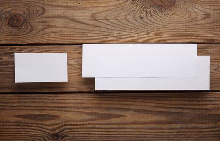 Mockup of two white blank tickets or flyers and business card on wooden background. Template for designの写真素材