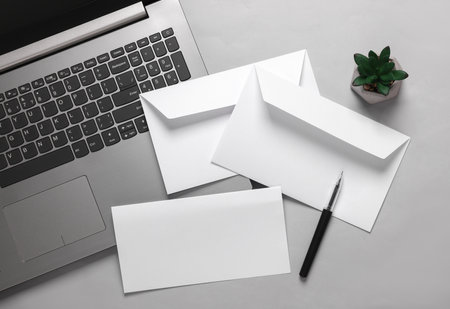 Creative business layout from white envelope with a letter and laptop on a gray background. Template for designの写真素材