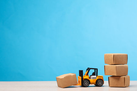 Forklift miniature with boxes on a blue background. Delivery, transportation, warehousing