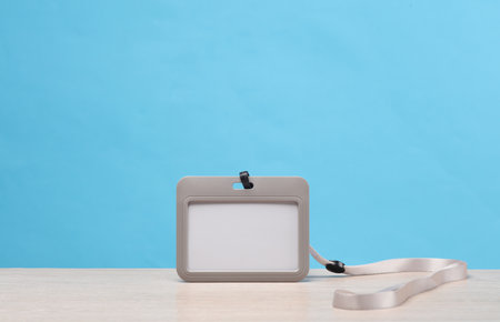White blank ID identification card on a belt, blue background. Template for designの写真素材
