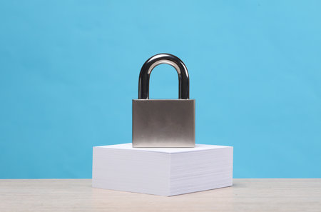 Padlock on a stack of memo papers, blue background. top secretの写真素材