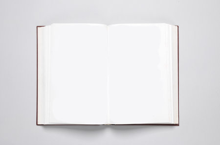 Open blank book with white pages on a gray background. Template for design, mock up