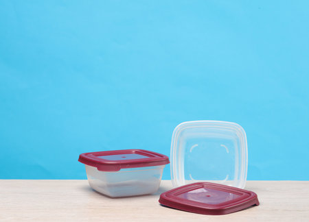 Plastic containers for food on the table, blue background