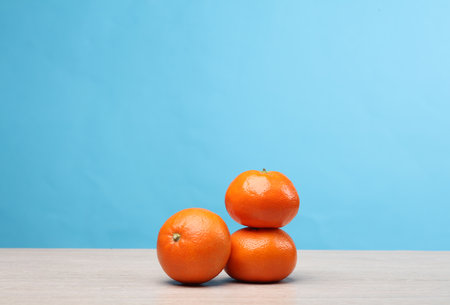 Ripe tangerines in peel on the table, blue backgroundの写真素材