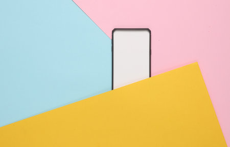 Black silicone case for a smartphone with a white tab on colored backgroundの写真素材