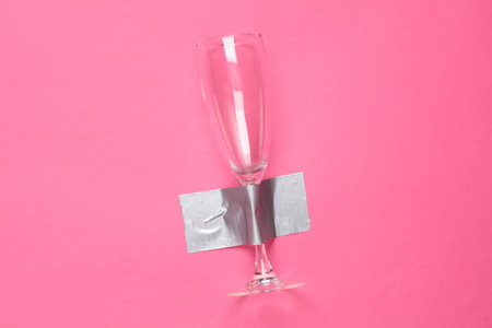 Glass fixed with adhesive tape on a pink background. food and drink. Conceptual pop, contemporary art, minimalist still lifeの写真素材