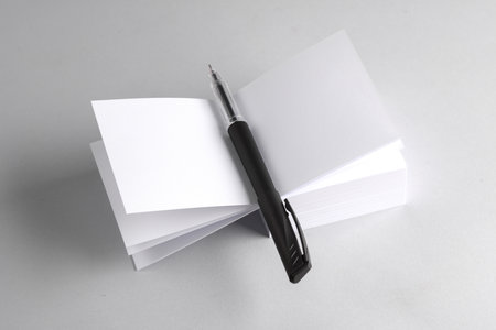 White blank square memo papers with pen on gray background