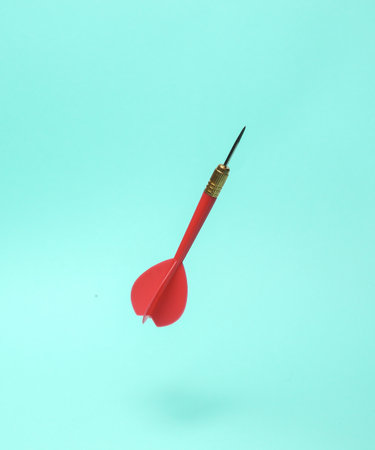 Red darts needle levitating on a blue backgroundの写真素材